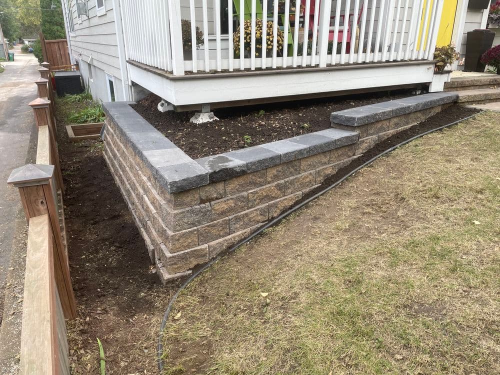 Retaining wall made of stone blocks, enhancing the landscape beside a porch.
